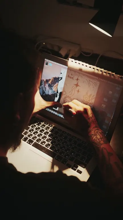 Still from the 7-minute founder-story VSL: a person working on a laptop at night under a desk lamp.